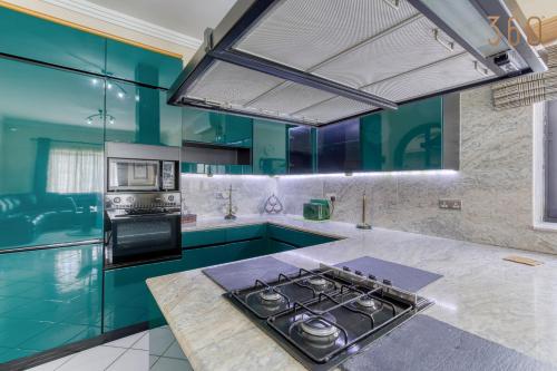 a kitchen with blue cabinets and a stove top oven at Spacious 4BR Villa with Private pool, parking & BBQ by 360 Estates in Tal-Mirakli