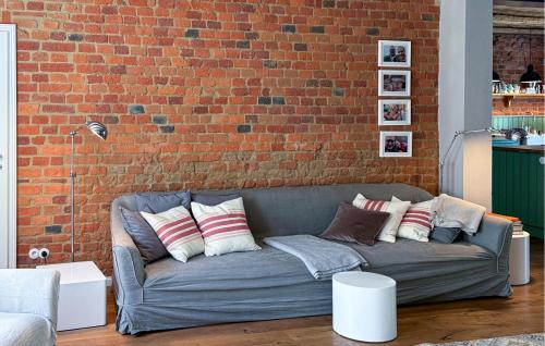 a couch in a living room with a brick wall at Awesome Home In Netzeband With Sauna in Netzeband