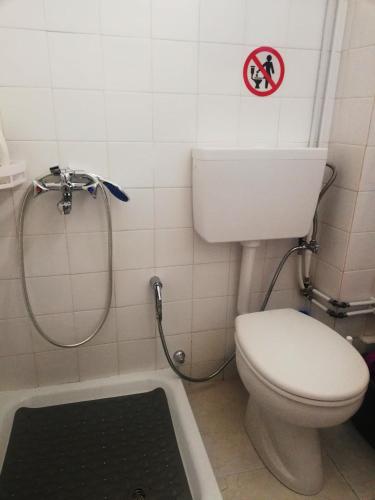 a bathroom with a toilet and a sign on the wall at Studio B3 in Mytilini