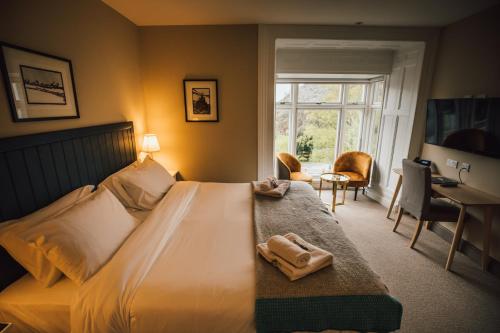 a bedroom with a bed with two towels on it at Plas Weunydd in Blaenau-Ffestiniog