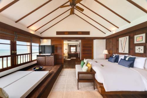 a large bedroom with two beds and a television at Napasai Samui in Mae Nam