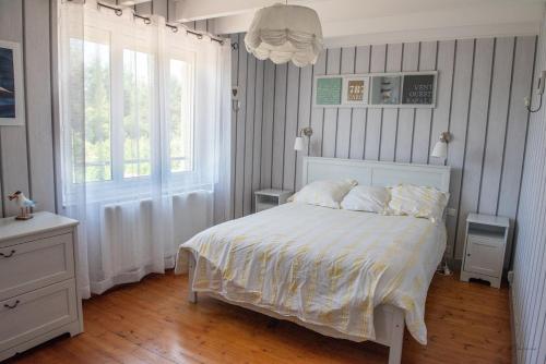 une chambre avec un lit blanc et une fenêtre dans l'établissement La Ferme Du Tôt, à Barneville-Carteret