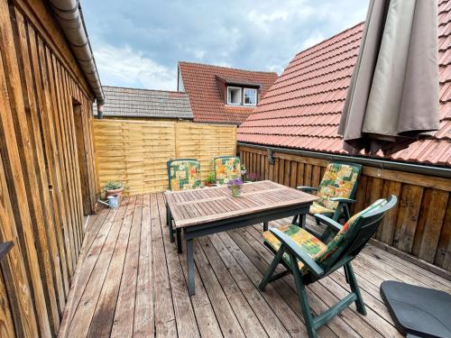 a wooden table and chairs on a wooden deck at Ferienwohnung Anneliese in Plau am See
