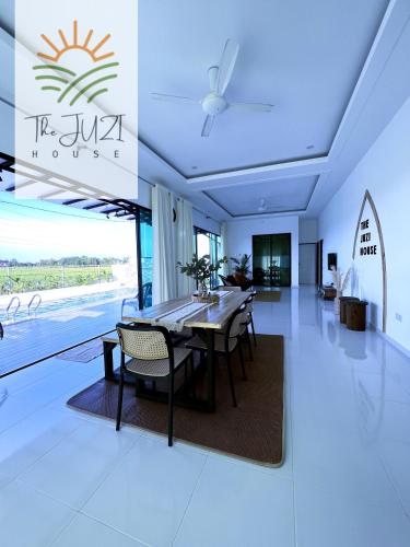 a dining room with a table and chairs in a building at The Juzi House - private pool homestay in Kuala Terengganu