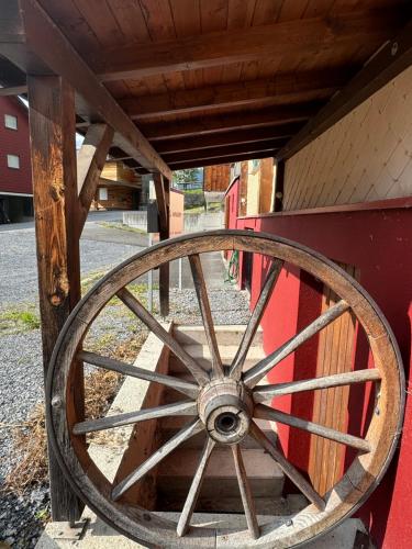a wooden wagon wheel sitting on the side of a building at AlpenHaus, farmhouse in Triesenberg