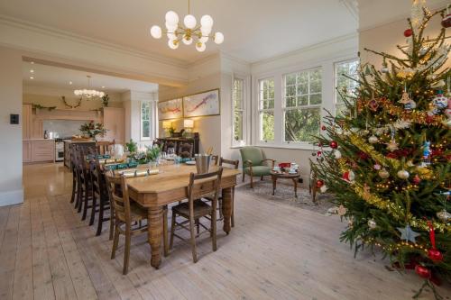 a dining room with a table and a christmas tree at Windy Ridge in Bembridge
