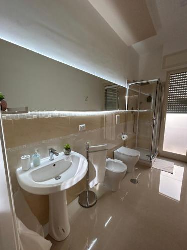 un bagno bianco con lavandino e WC di Casa Rosa a Poggiomarino