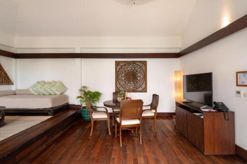 a living room with a bed and a table and chairs at Napasai Samui in Mae Nam