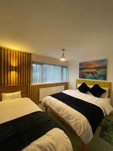 a bedroom with two beds and a painting on the wall at Musden Walk individual rooms in Manchester