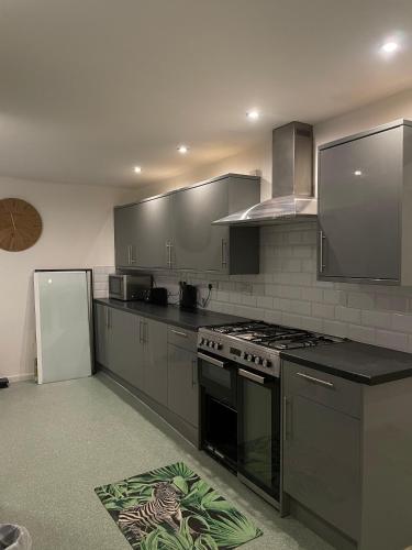 a kitchen with a stove and a refrigerator at Musden Walk individual rooms in Manchester