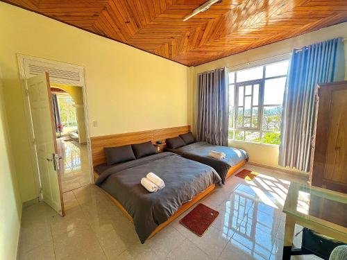 ein Schlafzimmer mit einem Bett und einem großen Fenster in der Unterkunft Pate's Home in Da Lat
