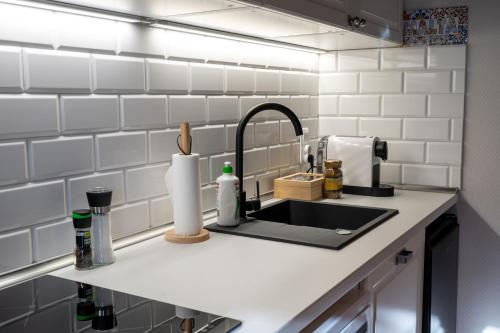 a kitchen counter with a sink and white tiled walls at Villa la Olive Premium Apartaments-Luxury Standard in Oświęcim