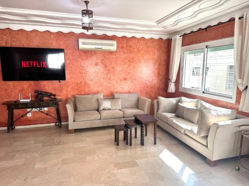 a living room with two couches and a television at Appartement centre-ville avec Wifi fibre optique in Fès