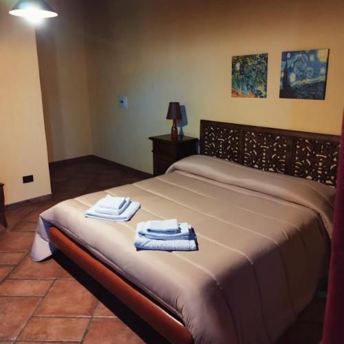 a bedroom with a bed with towels on it at Casale Valle Agnese in Godrano