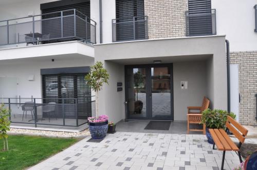 a house with a porch with a bench in front of it at Magnolia Apartman in Dunajská Streda