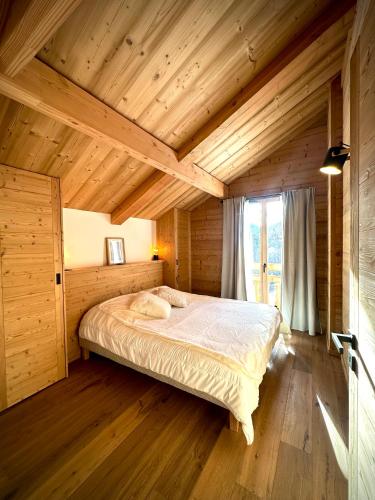 une chambre avec un lit dans une pièce en bois dans l'établissement L écrin de Pramorel, à Briançon