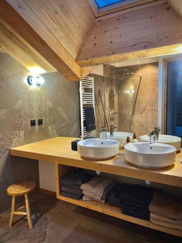 - une salle de bains avec deux lavabos sur un comptoir en bois dans l'établissement L écrin de Pramorel, à Briançon