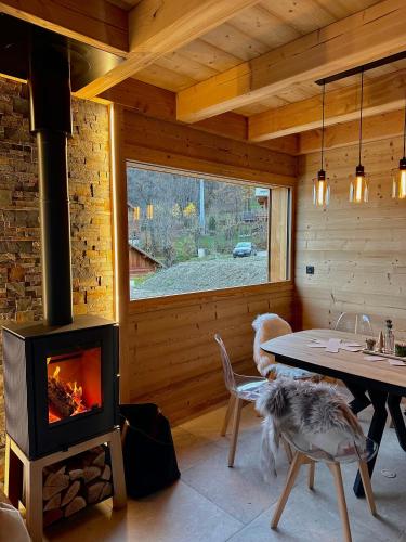 Cette chambre dispose d'une cheminée et d'une table avec un chien. dans l'établissement L écrin de Pramorel, à Briançon