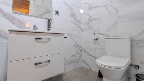 a white bathroom with a toilet and a sink at Hotel Barrio Húmedo by gaiarooms in León