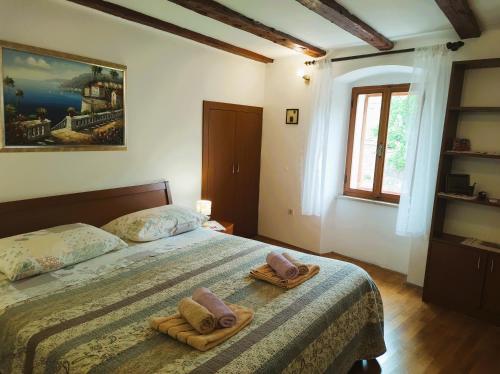 a bedroom with a bed with two towels on it at Apartment Rialto with private parking in Cres
