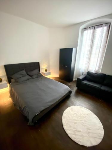 - une chambre avec un lit, un canapé et un tapis dans l'établissement Bel appartement face à la gare, à Veneux-les-Sablons