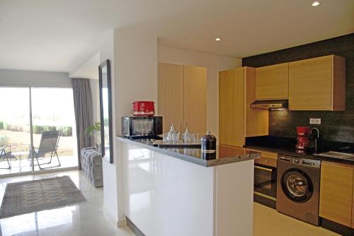 a kitchen with a counter top and a stove top oven at Appartement luxe vue Mer & Golf -Taghazout Bay in Taghazout