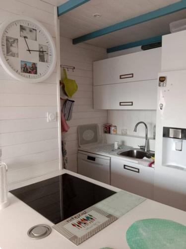 une cuisine avec un évier et une horloge murale dans l'établissement Appartement T2 vue Marina 2QMAR15 apartment one bedroom marina view, à Canet