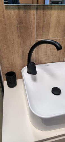 a kitchen counter with a sink with a black handle at Grand Apartman - 5 Star Luxury Podhajska Apartman in Podhájska