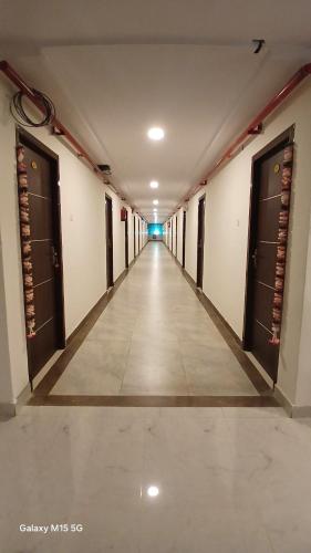 an empty hallway of a building with doors and a long corridor at K P M Lodge in Atmakūr