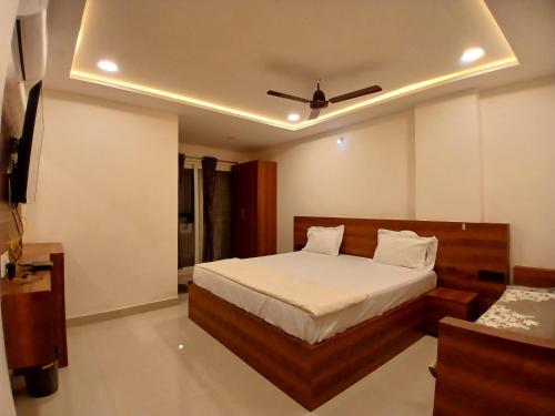 a bedroom with a bed with a ceiling fan at K P M Lodge in Atmakūr