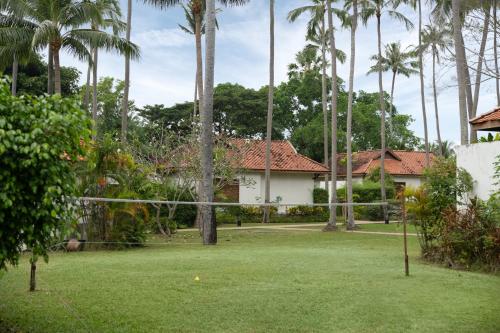 a yard with a volleyball net in front of a house at Napasai Samui in Mae Nam