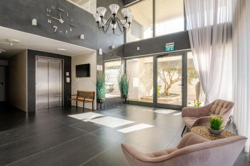 a living room with two chairs and a chandelier at Balfour sea view city center in Nahariyya