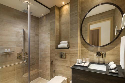a bathroom with a shower and a sink and a mirror at Millennium Al Barsha in Dubai