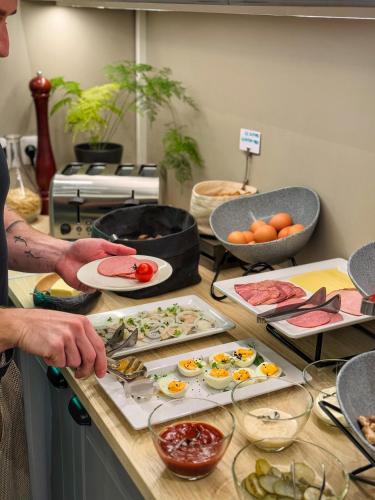 a man preparing food on a counter in a kitchen at Grand Baltic Dunes Hotel & SPA in Palanga