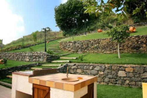a sink in front of a stone wall at Colina Da Faja in Fajã da Ovelha