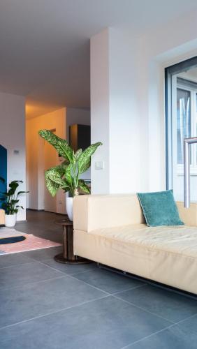 a white couch in a living room with plants at Appartamento Angeli in Levico Terme