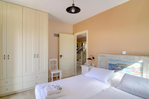 a bedroom with a white bed and a staircase at Nikoloudi Estate in Agios Nikolaos