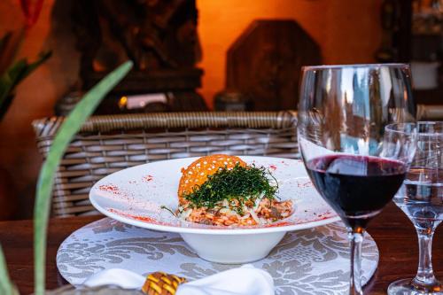 a plate of food on a table with a glass of wine at Pousada Do Lado de Lá in Pirenópolis