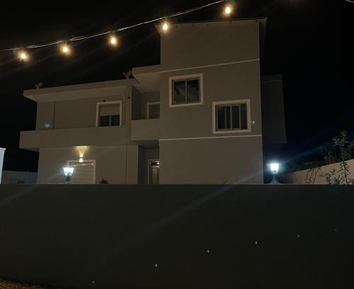 a house with lights on top of it at night at Xhefri's Apartments in Vlorë