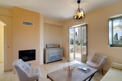 a living room with a table and chairs and a fireplace at Nikoloudi Estate in Agios Nikolaos