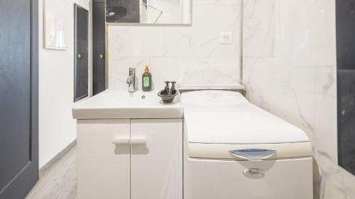 une salle de bain blanche avec des toilettes et un lavabo dans l'établissement Les Suites du Jardin 4 - L'irrésistible - Hypercentre, à Chaumont