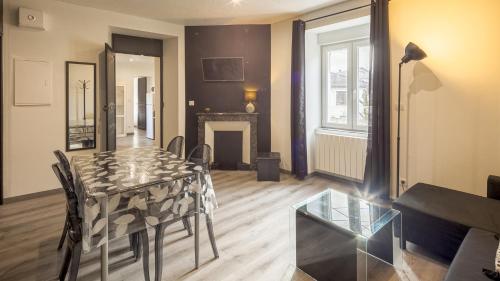 un salon avec une table et une cheminée dans l'établissement Les Suites du Jardin 4 - L'irrésistible - Hypercentre, à Chaumont