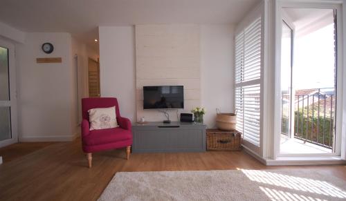 ソルカムにあるJacks Stay, 2 bedroom apartment in Salcombeのリビングルーム(赤い椅子、テレビ付)