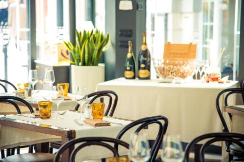 a restaurant with tables and chairs with wine glasses at Hotel Royal Victoria, by R Collection Hotels in Varenna