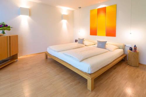 a large bed in a room with a painting on the wall at Hotel Schindlerhof in Nürnberg