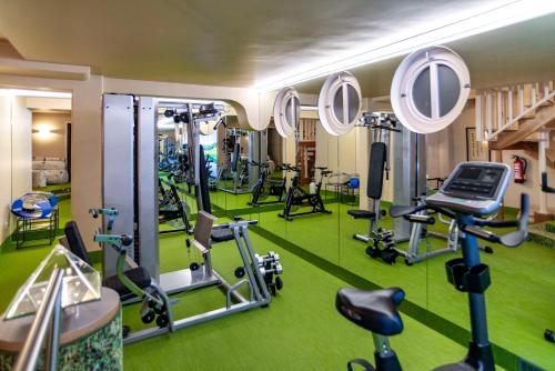 a gym with exercise equipment on a green floor at Hotel Schindlerhof in Nürnberg