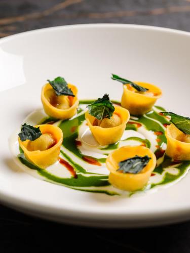 a plate of food with oranges and greens on it at Hotel Royal Victoria, by R Collection Hotels in Varenna