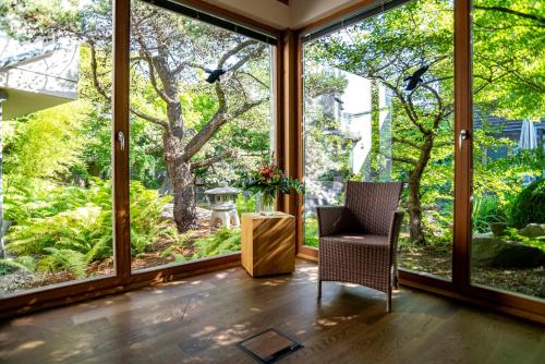a room with large windows with a chair and a table at Hotel Schindlerhof in Nürnberg