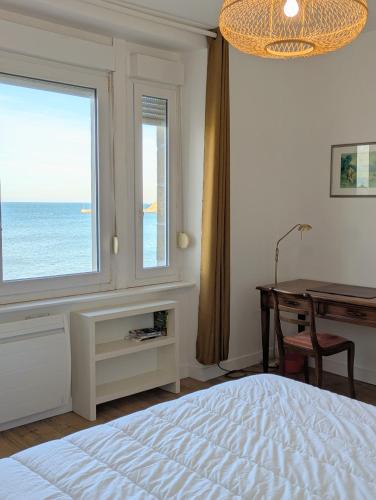une chambre avec un lit, un bureau et une fenêtre dans l'établissement Maison Ty Bihan face à la plage de Pleneuf, à Pléneuf-Val-André