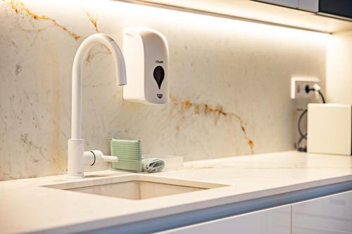 a kitchen sink with a faucet on a counter at Apartamentos París Boutique Valladolid in Valladolid
